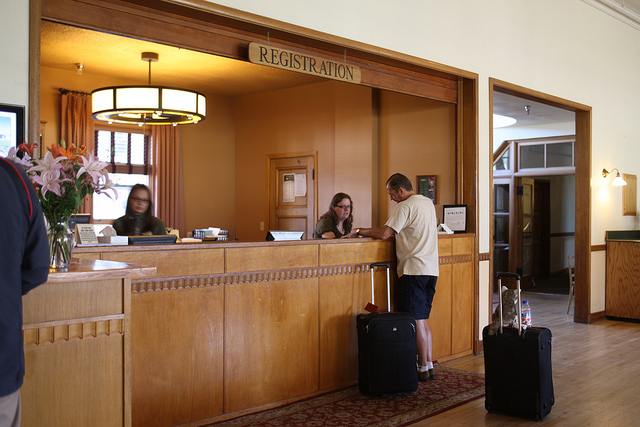 A man checking out of the Mammoth Hot Springs Hotel registration desk in Yellowstone National Park