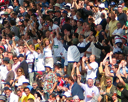 A photo of a large group of people all sitting on stadium benches