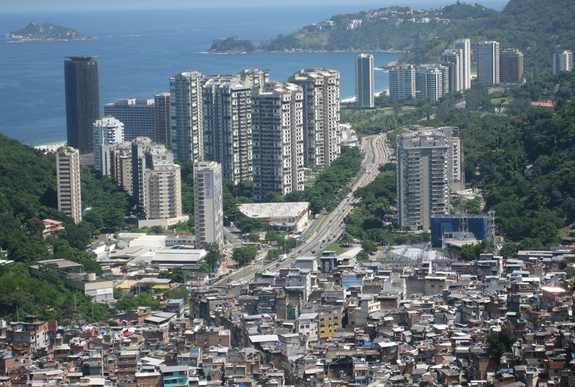 This photo is of a city with large high rises in the background and a slum in the foreground.