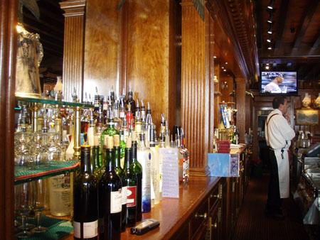 A bartender standing behind a bar.