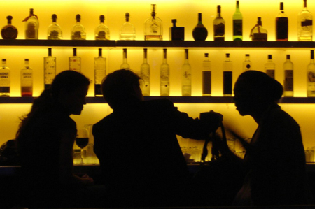 Silhouetted figures in a bar.