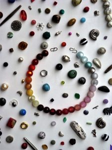 Image shows scattered beads and a beaded bracelet.