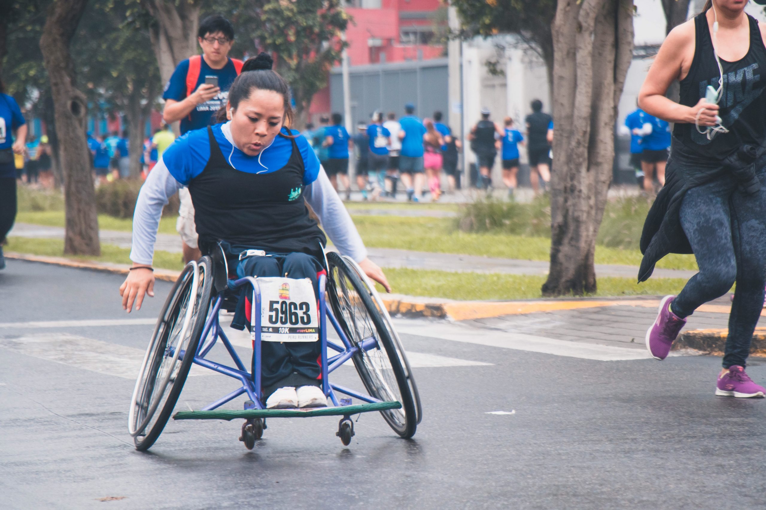 Image shows a woman in a wheelchair taking part in a marathon.