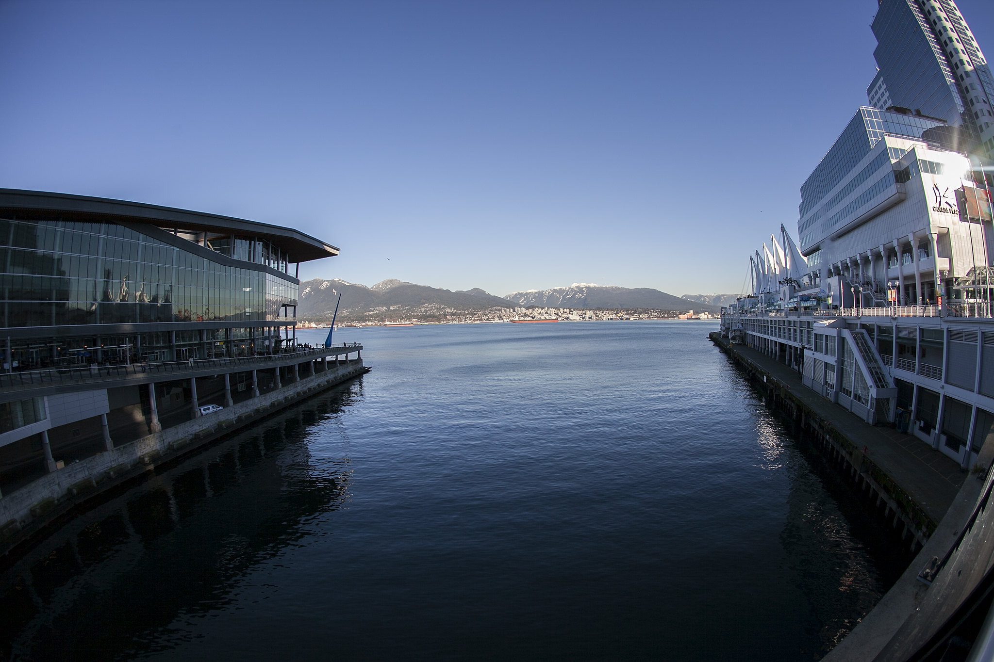 A small inlet with an event centre with many windows on one side and a tall hotel on the other.