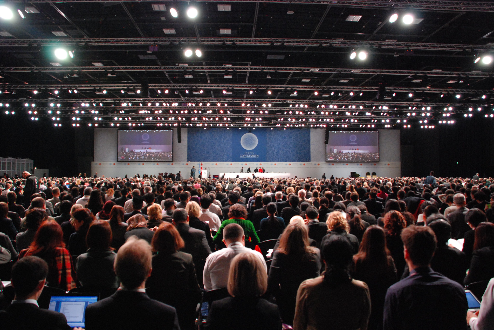 A large crowd of people sit in an auditorium.