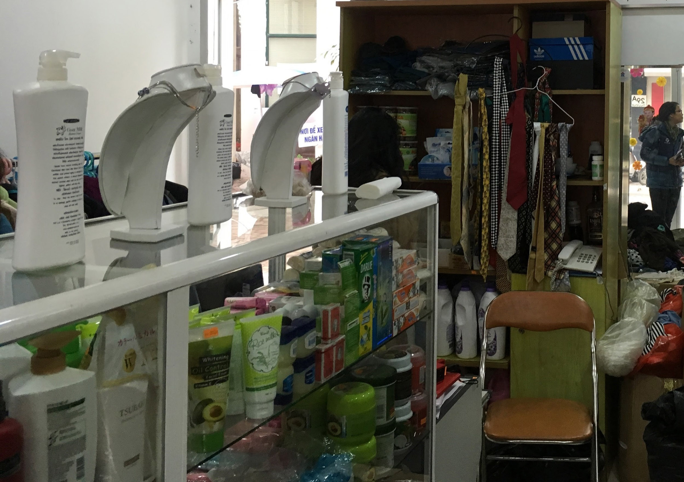 A glass case within a shop that holds necklaces, lotion, and other products.