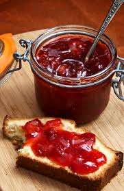 a jar of jam and some jam spread on toast