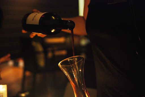 This photo shows wine being poured into a glass container.