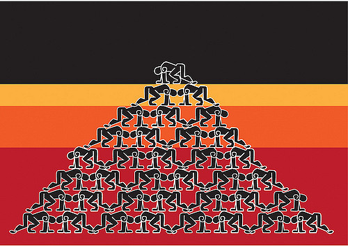 Image of people crouching on top of one another to form a pyramid.