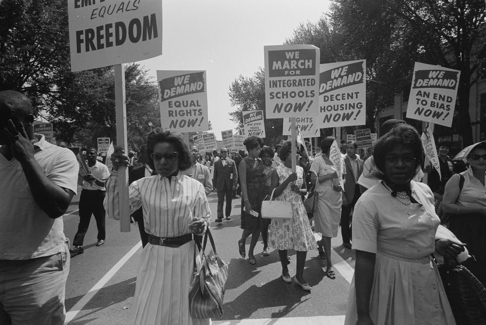 Photo of marchers holding signs demanding equal rights.