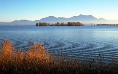 Water surface of a river is shown, with mountains in the background. There are small ripples over the water surface.