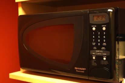A microwave oven is shown with some food on the nonmetal plate inside it.