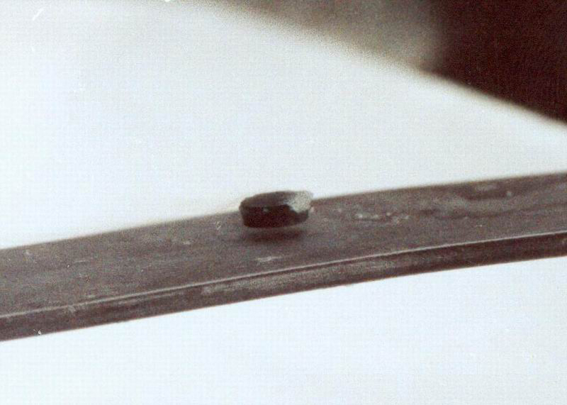 The figure shows a button-shaped magnet floating above a superconducting puck. Some wispy fog is flowing from the puck.